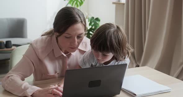 Mom and Son Working Together on the Computer Learning Programs Playing Video Games alt