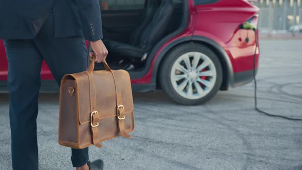 Close Up of African American Man in Formal Suit Connecting Charging Cable to alt