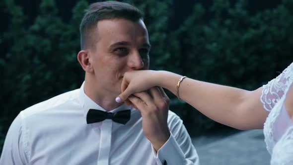 The Groom Kisses the Hand of the Bride and Smiles alt