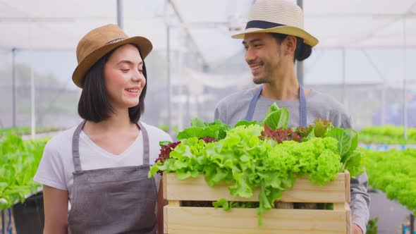 Asian couple people farmer owner working in vegetables hydroponic green house farm with happiness. alt