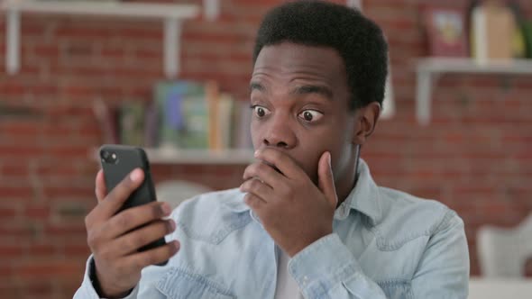 African Male Having Loss on Smartphone  alt