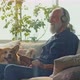 Cheerful Old Man Pets Adorable Corgi Dog Sitting on Comfortable Sofa - VideoHive Item for Sale