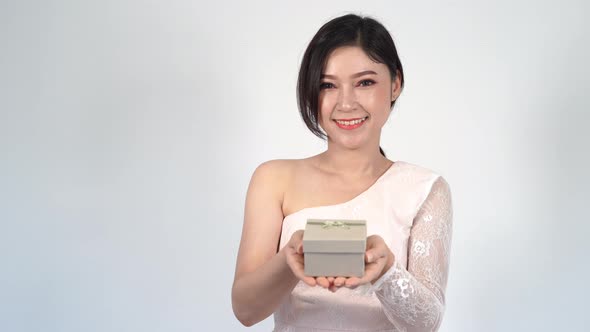 woman holding a gift box in a gesture of giving.