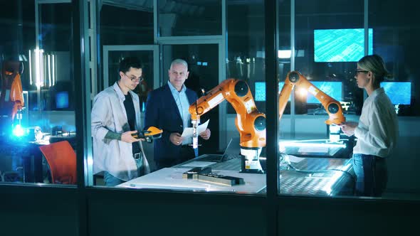 IT Laboratory with Engineers Discussing a Robotic Device alt