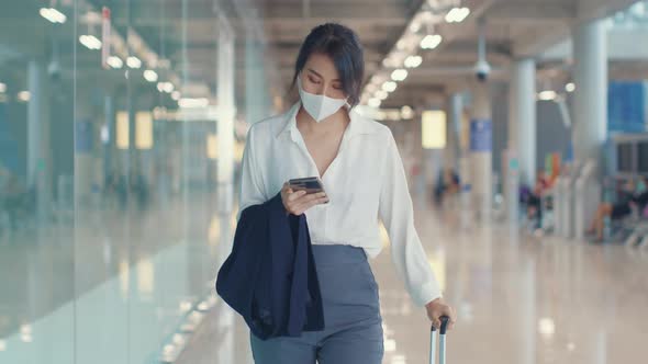 Asian business girl use smart phone for check in boarding pass walk with luggage to terminal.