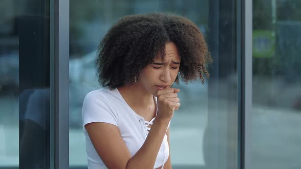 African American Girl Has Sore Throat, Holds By Neck, Became Ill on Street, Close Up. First Symptoms alt