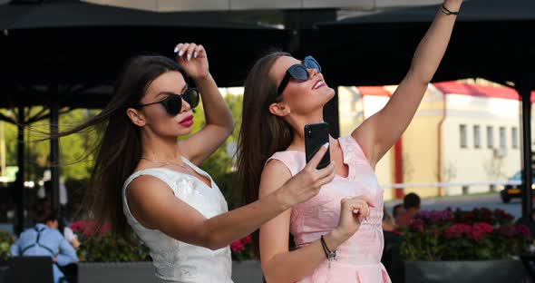 Two Fashionable Woman with Red Lips Making Self Portrait at Smart Phones