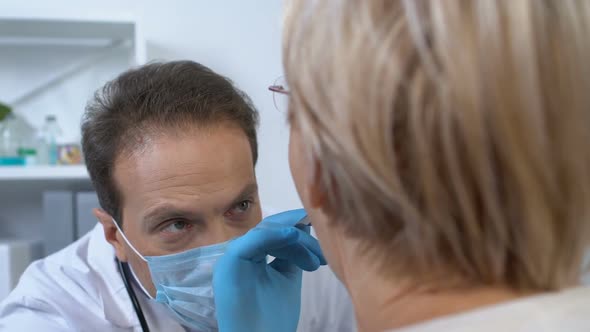 Male Otolaryngologist in Mask Checking Female Patient Throat, Health Examination