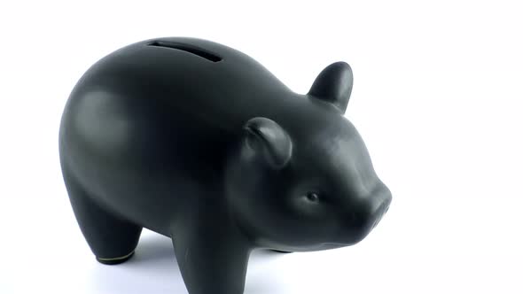 Male Inserting British Pounds into a Piggybank alt