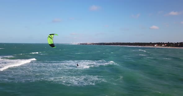 Aerial drone view of a man kiteboarding on a kite board. alt