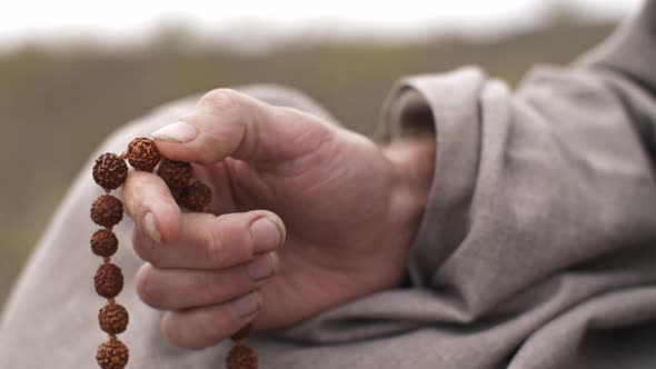 Man Meditating with Beads alt