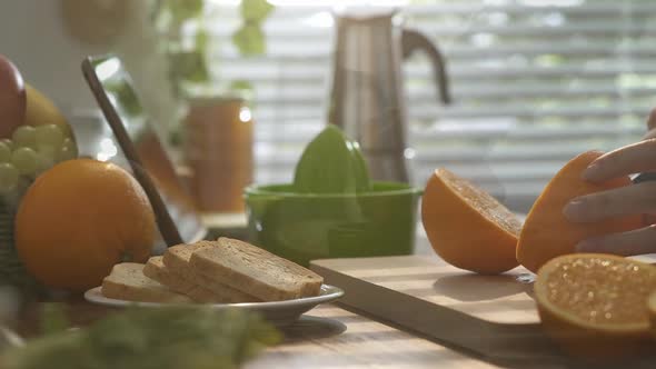 Woman preparing an healthy orange juice for breakfast