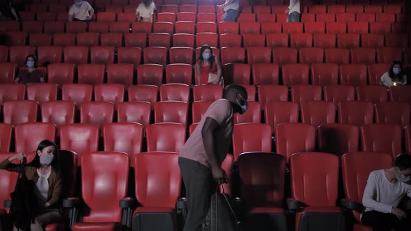 Diverse Audience in Masks Taking Seats in Cinema alt