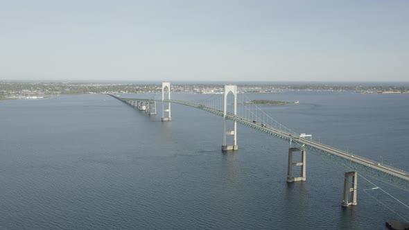 Drone shot of a big bridge that crosses the water,ing forward and slowly tilting down. alt