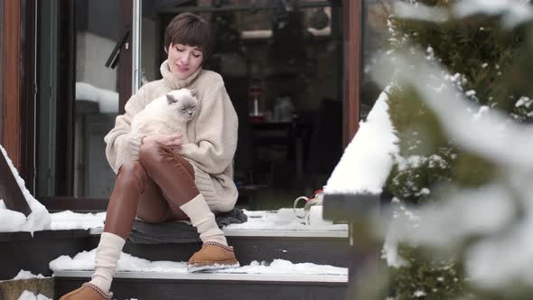 Peaceful Young Woman Drink Tea on Home Terrace in Winter alt