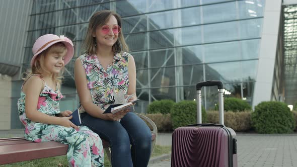 Mother and Daughter Near Airport. Woman Hold Passports and Tickets in Hand. Child and Mom Vacation alt