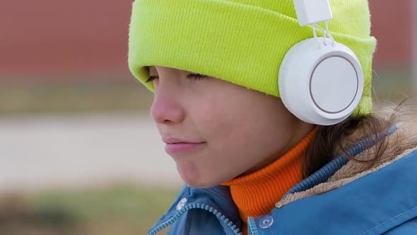 Overconfident and Insolent Teenager Girl Listening to Rap Music Through White Wireless Headphones alt