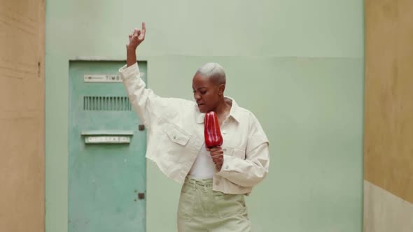 Slow motion of woman singing and misusing red pepper as microphone alt