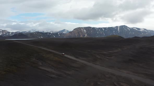 Top View Car Driving Desert Black Volcanic Terrain Speeding Up in Iceland Highlands alt