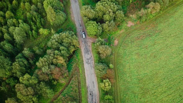 Aerial View of White Car Driving on Road Among Green Forest and Railway