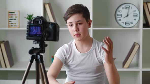 Portrait of Boy Videoblogger 13 Years Old Filming New Vlog Video with Professional Camera at Home alt