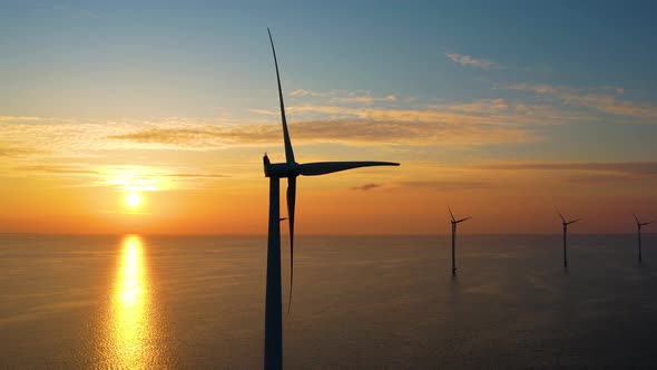 Working offshore wind farm, sunset view. Aerial view of wind turbines in Windpark, Netherlands.