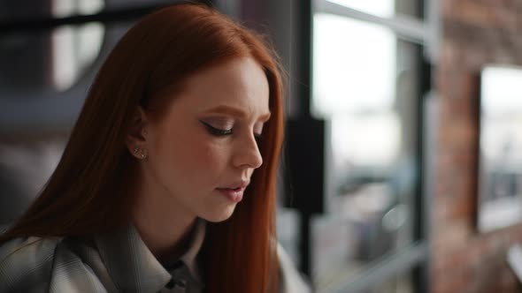 Closeup Face of Pensive Redhead Young Woman Working on Laptop Computer Looking Away Thinking Solving alt