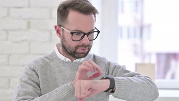 Young Designer Using Smartwatch in Modern Office alt