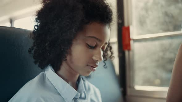 African American Schoolgirl Looking Camera in School Bus Close Up alt