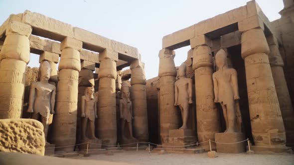 Tall pillars and pylons with rock statues in the Karnak Temple, Luxor, Egypt. Slow camera movement alt