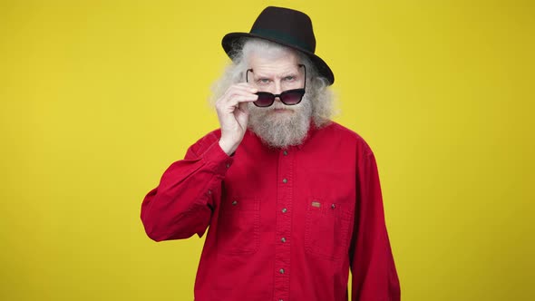 Middle Shot Portrait of Confident Senior Bearded Man Putting on Sunglasses Putting Hands on Hips and alt