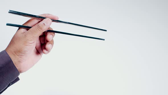 Hand Holds Metal Chopsticks  alt