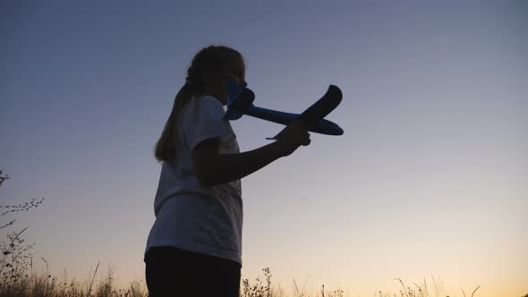 Carefree Little Child Holds in Hand Airplane Walking at Dusk Time alt