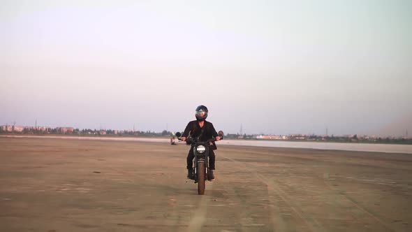 Front View of Young Biker in Helmet and Jacket Man is Riding at Sport Motorbike alt