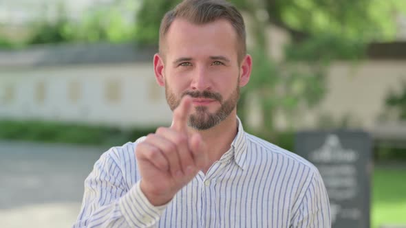 Outdoor Portrait of Middle Aged Man Pointing at Camera Inviting alt