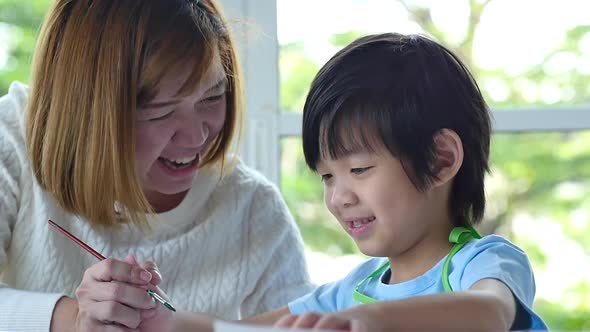 Cute Asian Child And Mother Painting Together alt