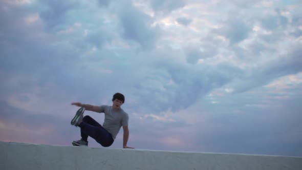 Young Dexterous Caucasian Male Perfoming Parkour Exercises Using Parapet alt
