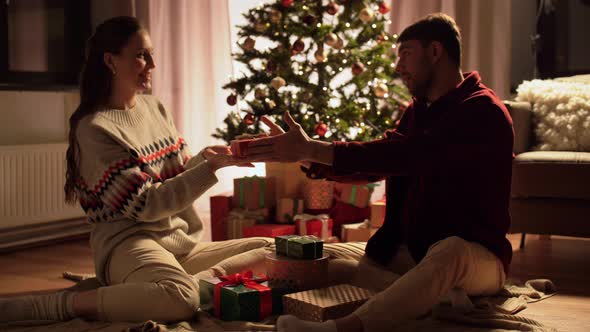 Happy Couple with Christmas Gifts at Home