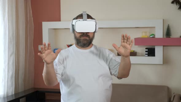Bearded man playing game in vr glasses, touch something using modern virtual reality glasses . 