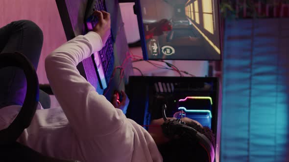 Over Shoulder View of African American Gamer Using Pc Gaming Setup Relaxing Playing First Person alt