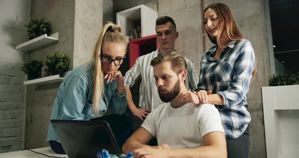 Team Working on Laptop in Loft Office