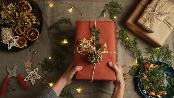 Woman Puts Christmas Present on Table alt