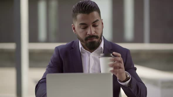 Serious Man Working with Laptop Outdoor alt