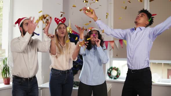 Group of Multiethnic Office Workers Partying in the Office Throwing Golden Confetti Blowing Confetti alt