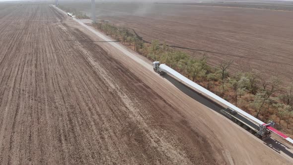 Truck Transports Blade for Wind Turbine Along Rural Road