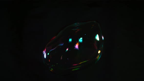 Super Slow Motion Shot of Flying and Cracking Colorful Soap Bubble Isolated on Black at 1000 Fps alt