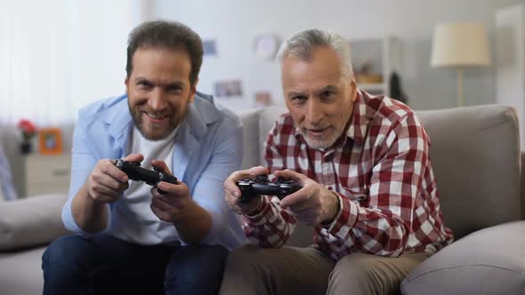 Two Adult Men Winning Video Game Giving High-Five, Celebrating Victory, Leisure alt