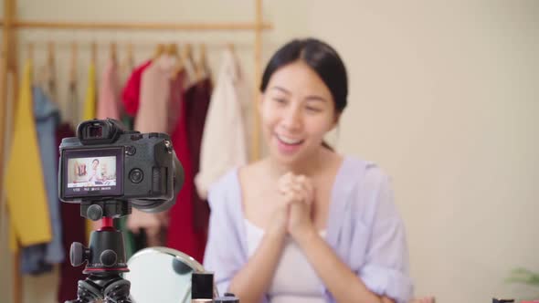 Beauty blogger present beauty cosmetics sitting in front camera for recording video Asian woman. alt