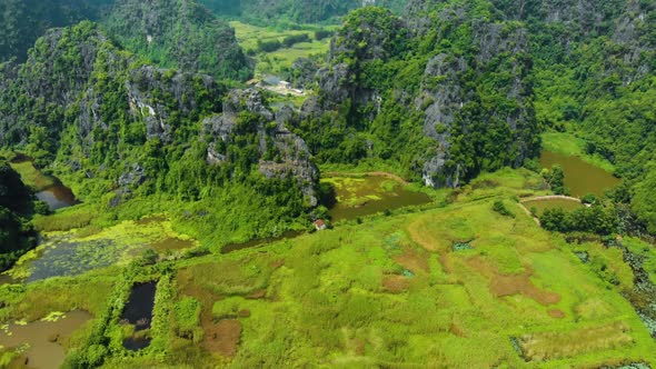 Aerial: North Vietnam karst landscape at sunset, drone view of Ninh Binh region, tourist destination alt