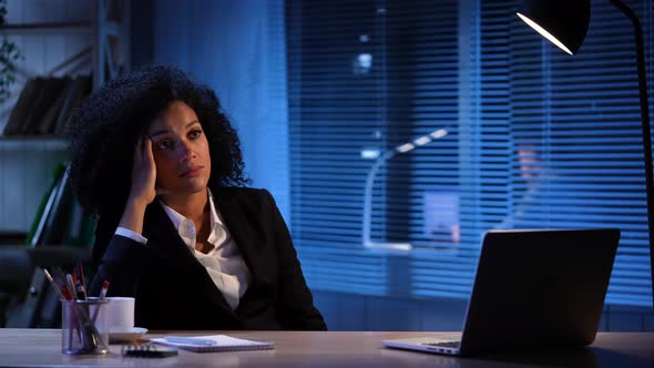 Portrait of Tired African American Woman Against the Background of Turning on and Off the Light alt